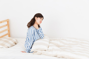 パジャマを着た女性　ベッド　疲労