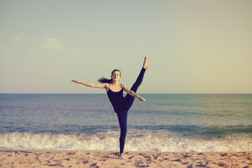 Fototapeta premium Woman is doing fitness, sunny blue sky sand beach outdoors background