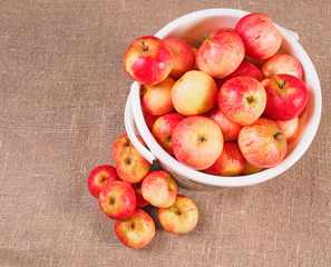 Basket with apples on a wooden background.