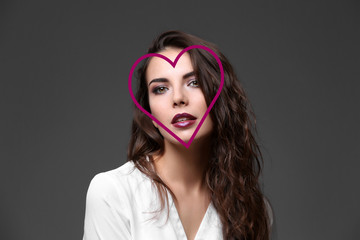 Beautiful woman with heart shaped face on dark gray background
