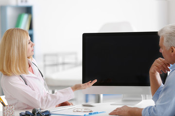 Doctor showing analysis result to aged man