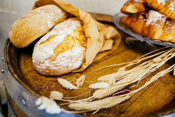 Fresh bread with wheat and croissant on a wooden