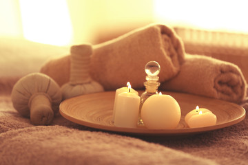 Spa set with candles, oil  and towel on blurred background