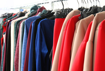 Rack with different clothes in modern shop, closeup