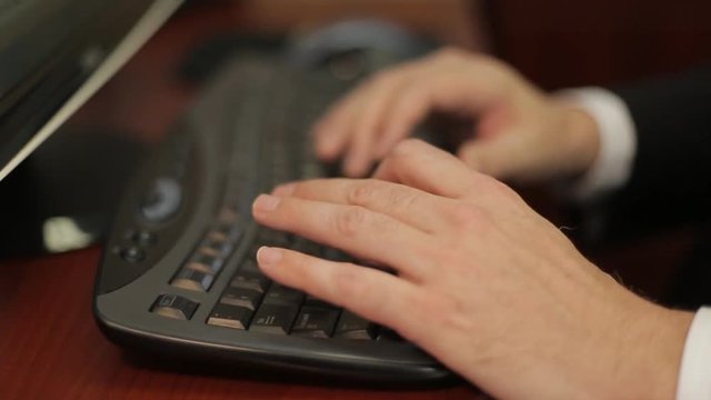 Men's hands typing on a keyboard