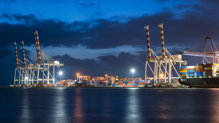 Obraz premium Container ship in import, export port against twilight