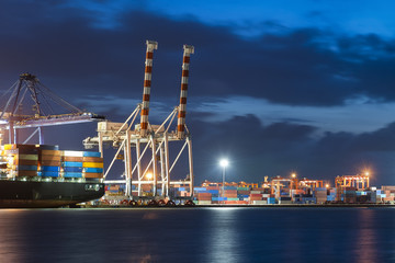 Obraz premium Container ship in import, export port against twilight