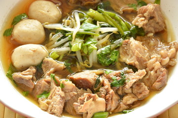braised pork and bean sprout in brown soup on bowl