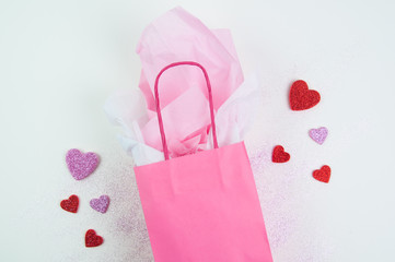 Obraz na płótnie Canvas Pink gift bag with glitter hearts and glitter for valentine's day