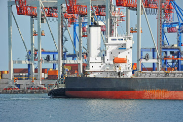Tugboat assisting bulk cargo ship