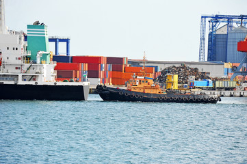 Tugboat assisting bulk cargo ship
