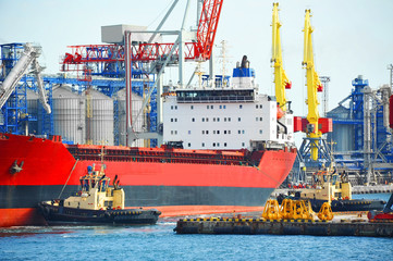 Tugboat assisting bulk cargo ship