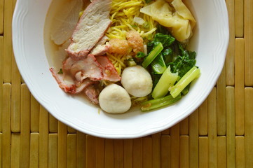 Chinese egg noodle topping fish ball and dumpling with Slice barbecue pork in soup