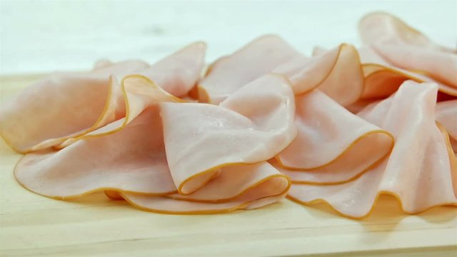 Slices of pork ham on wooden board, making sandwich, dolly shot