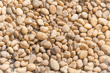 Small beige color round stone gravel background texture. rocky, stony pebbles.