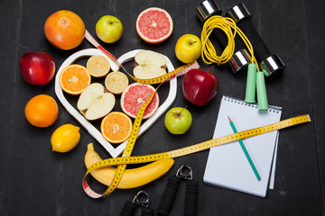 Diet plan, fruits and centimeter on a black background - 135130330