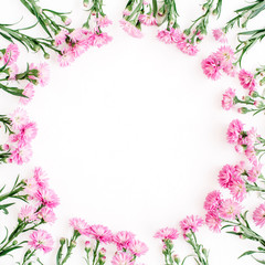 Obraz na płótnie Canvas Wreath frame made of pink wildflowers, green leaves, branches on white background. Flat lay, top view. Valentine's background