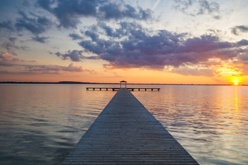 Fototapeta na wymiar wooden pier overlooking the lake, the beautiful evening sky 