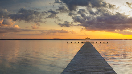 wooden pier overlooking the lake, the beautiful evening sky, colored by the setting sun 