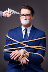 Businessman taken hostage and tied up with rope