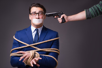 Businessman taken hostage and tied up with rope