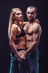 Fototapeta na wymiar Sexy couple in jeans. Boyfriend and girlfriend embracing in the dark.