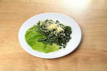 dish of green beans on  white plate  wooden background