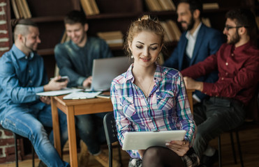 assistant young woman with laptop on the background of business 