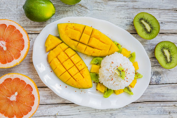 Fresh mango and kiwi with rice on white plate.