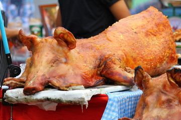 Golden whole roasted pig. Spit roasting is a traditional international luau method of cooking a whole pig. - obrazy, fototapety, plakaty
