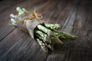 Closeup shot of fresh asparagus bunch on wooden rustic background
