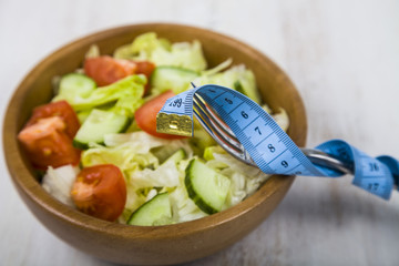 Salad in wooden bowl on a table close-up.