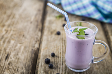 Smoothies or yogurt with fresh berries on a wooden table.
