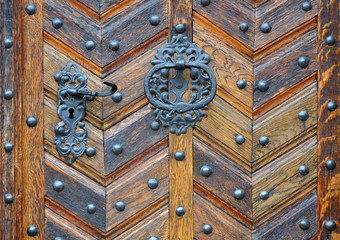 Vintage wooden door texture with round metal elements.