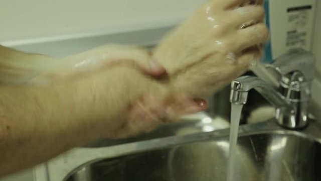 Doctor washes hands, close-up of man washes hands with soap, safety.