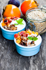 fruit  crumble with oat flakes and persimmon and fig on rustic w