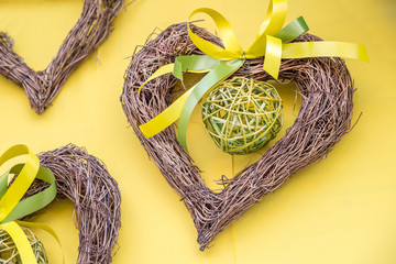 spring decor. Heart from branches on yellow background