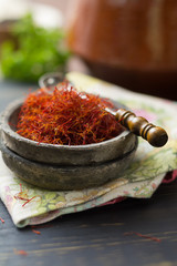 Raw Organic Red Saffron Spice in a clay bowl