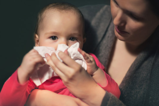 Woman wipes snivels daughter with handkerchief
