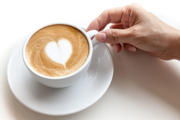 Hand holding coffee cup of latte art heart shape on white backgr