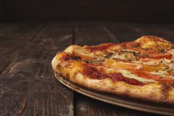 Close up delicious pizza on dark wooden background