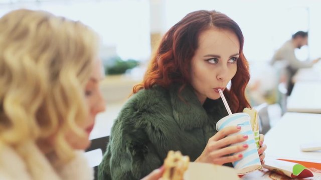 two woman eating junk food