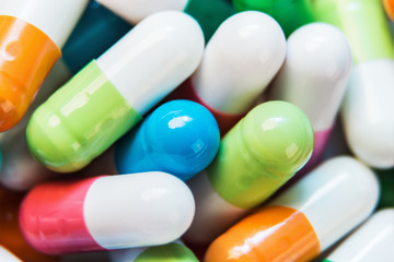 pills of different colors background. soft focus