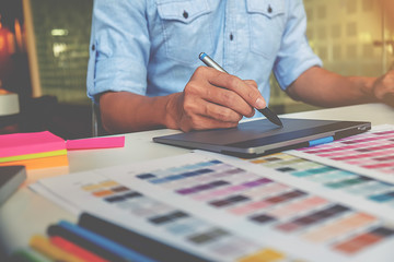 Artist drawing on graphic tablet in office