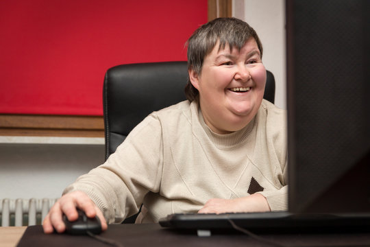 geistig behinderte Frau sitzt am Computer, Bildung und Therapie