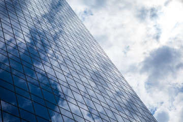 Fototapeta na wymiar Blue office building with clouds reflection