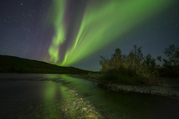 Aurora Borealis over the river. River Paypudyna. Polar Urals. Russia.