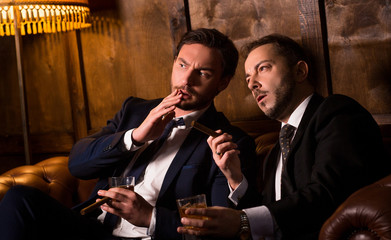 Rich men spending time in men's club and solving global problems. Collusion in business and global conspiracy between two successful businessmen.