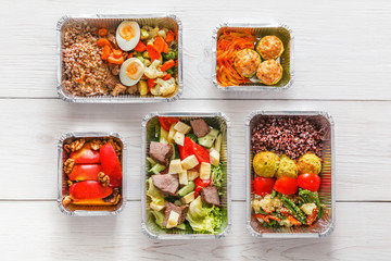 Healthy food take away in boxes, top view at wood