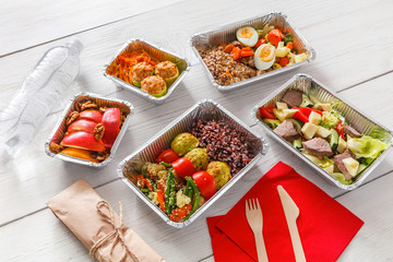 Healthy food take away in boxes, top view at wood